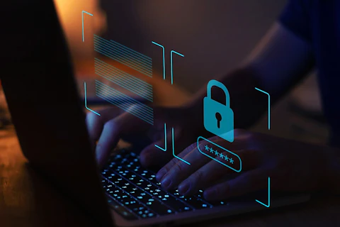 Symbole zamkniętej kłódki i gwiazdek, w tle osoba pisząca na klawiaturze laptopa.